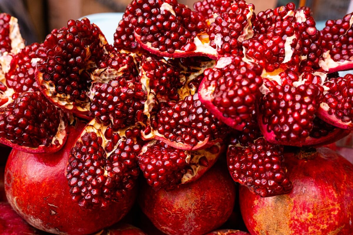 Fresh pomegranates with seeds exposed on display at a vibrant Marrakesh market stall.